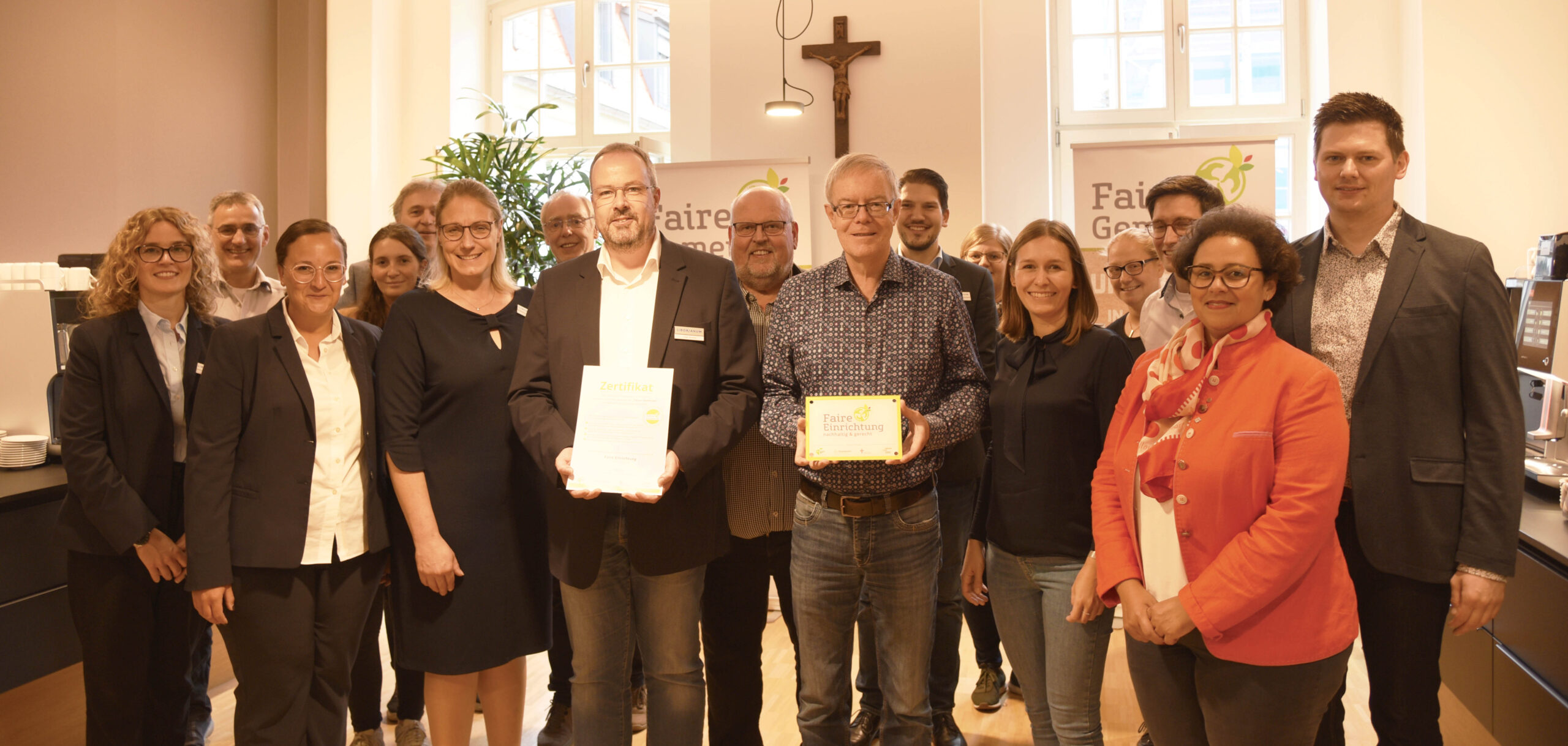 Dr. Christian Föller und Nadine Mersch vom Diözesankomitee der Katholiken im Erbistum Paderborn überreichen den Mitarbeitenden des Liborianums die Auszeichnung als 